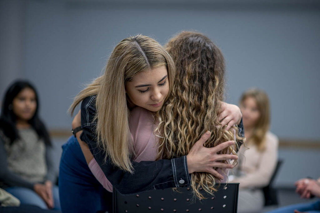 Two women hugging each other