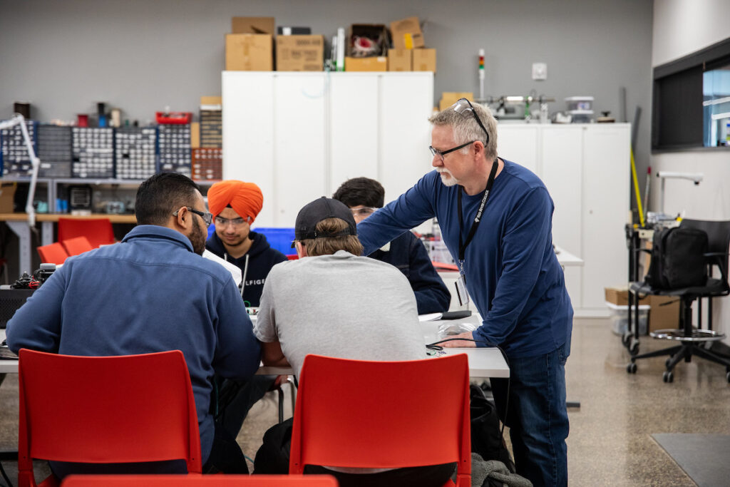 Instructor with a group of students in an electronics lab.