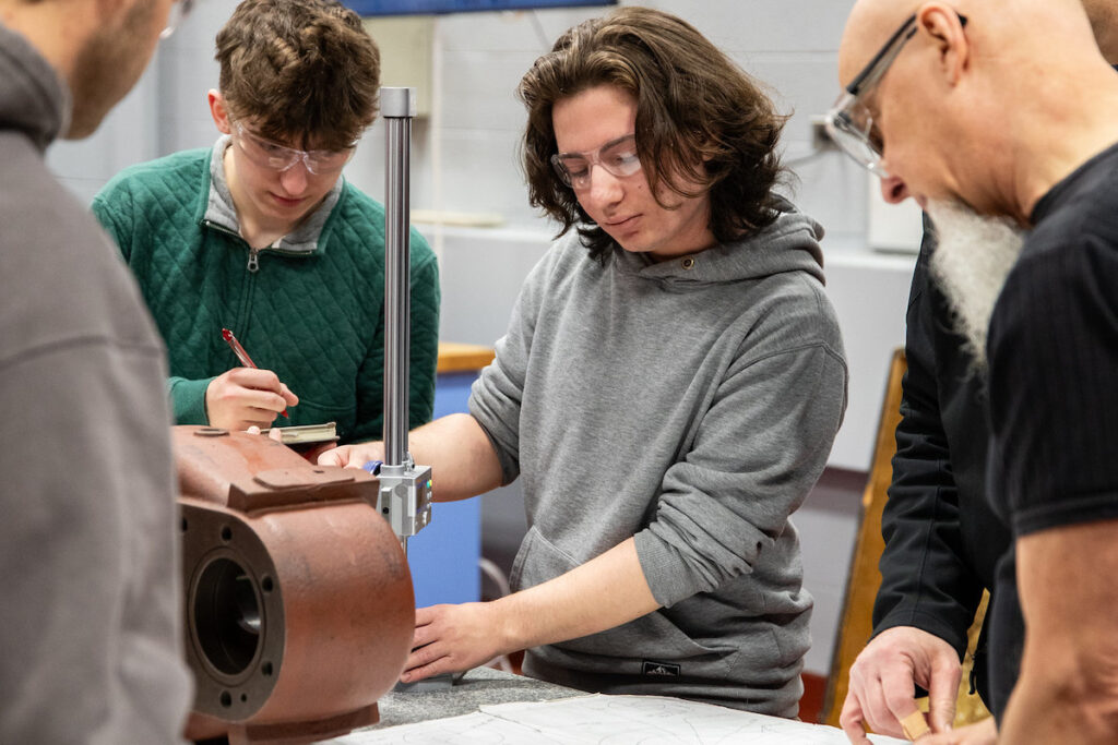 Students and instructor working together in a shop environment.